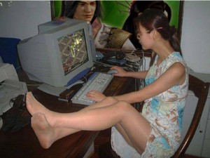 teenage girl skirt legs on the table playing internet gaming computer in Vietnam Cu Lao Tien Giang Go Cong Tan Thoi Tan Phu Dong