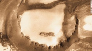 Although it is 45 kilometers (28 miles) wide, countless layers of ice and dust have all but buried the Udzha Crater on Mars. The crater lies near the edge of the northern polar cap. This image was taken by NASA's Mars Odyssey Orbiter in 2010.